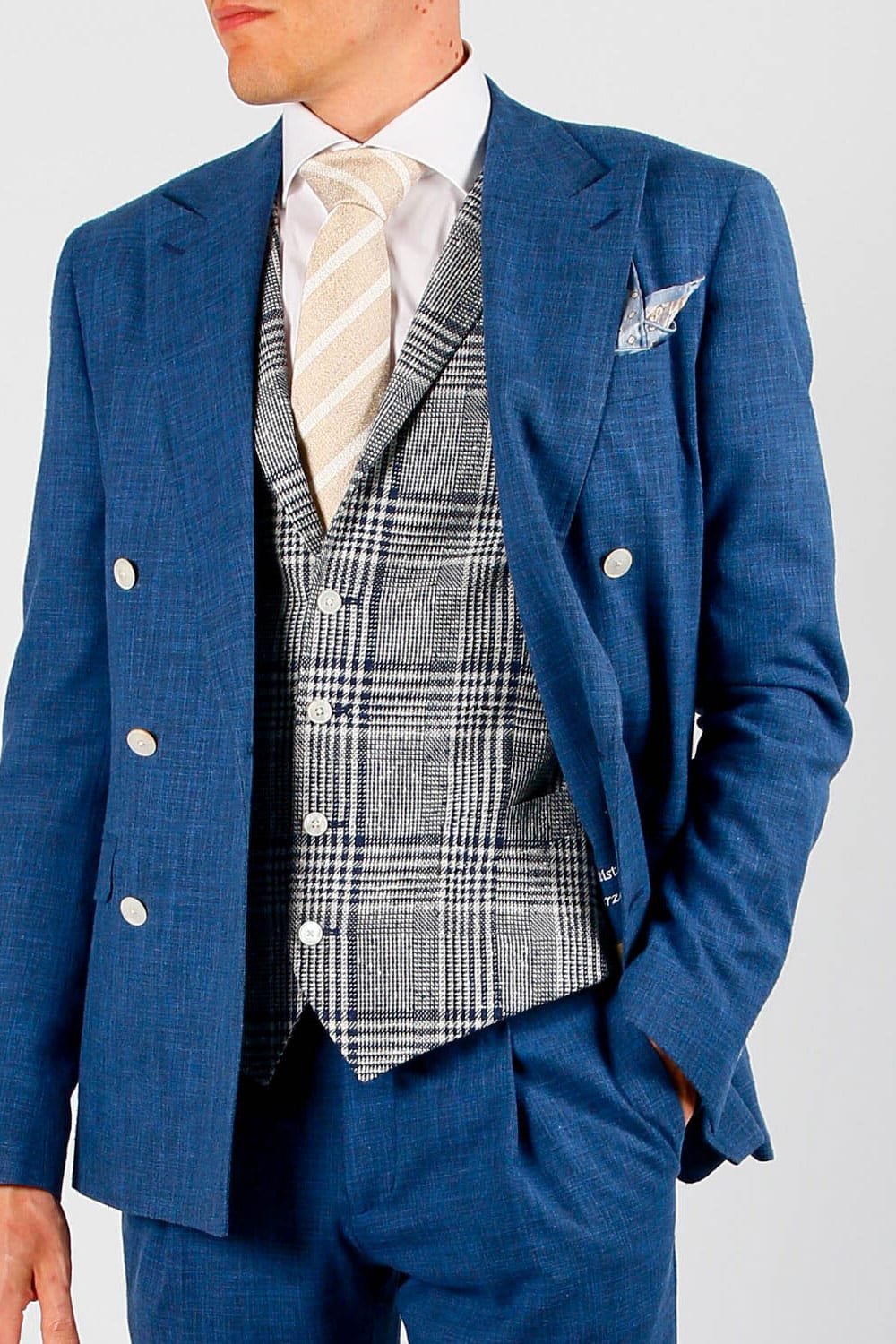 Close up op een driedelig blauw kostuum met contrast gilet.