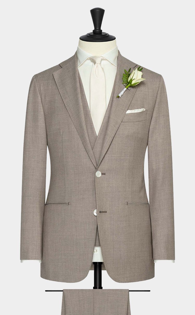 Een driedelig beige trouwkostuum.